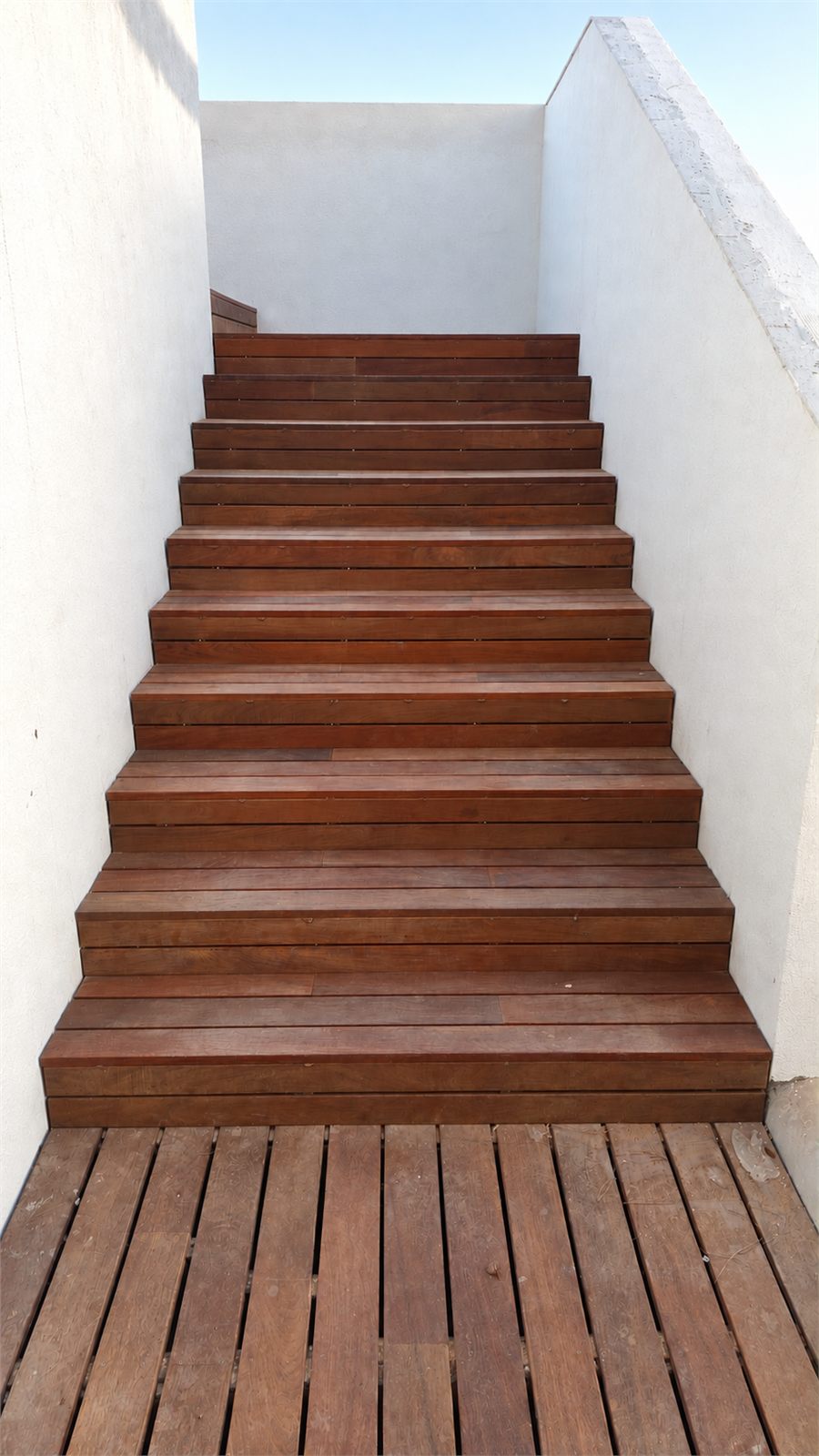Escalera exterior de tarima de madera junto a una piscina en Llíria